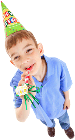 Young boy wearing birthday hat and blowing noisemaker