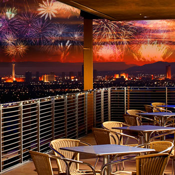 The Las Vegas Strip at night with fireworks, as seen from the balcony at Divine Cafe