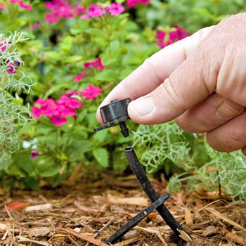 Close up of a hand adjusting a drip emitter