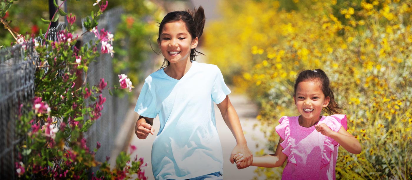 Two young girls holding hands and running in Boomtown