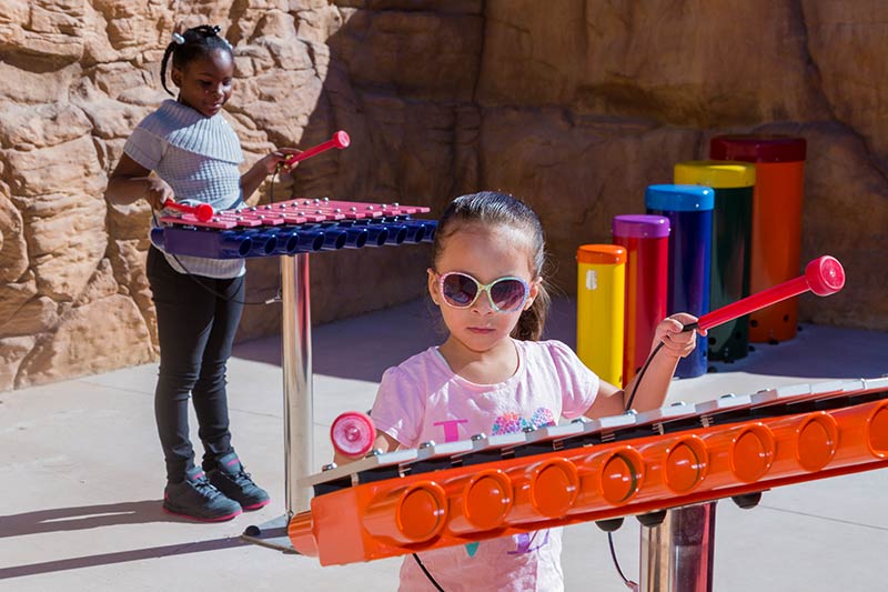 Children on playground playing musical instruments